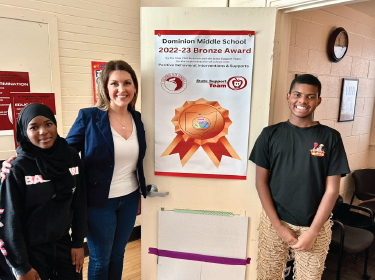 students posing in front of banner